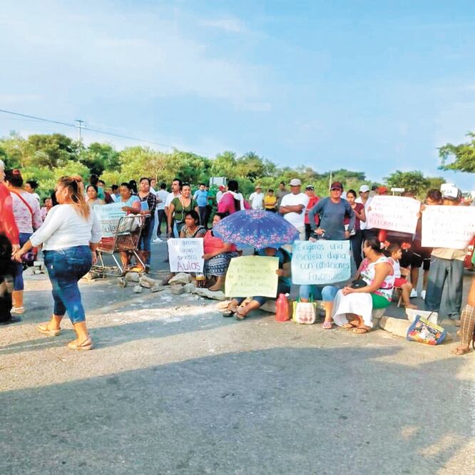 Padres de familia y maestros de los planteles de la Zona Escolar de Educación Bilingüe bloquearon ayer la carretera federal Panamericana. ROSELIA CHACA. EL UNIVERSAL