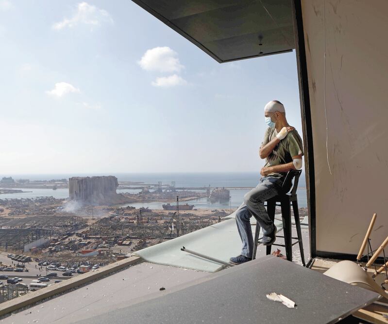 Tony Ahwaji, productor de televisón libanés, observa desde el balcón de su departamento los daños por la explosión en Beirut. Foto: PATRICK BAZ. AFP