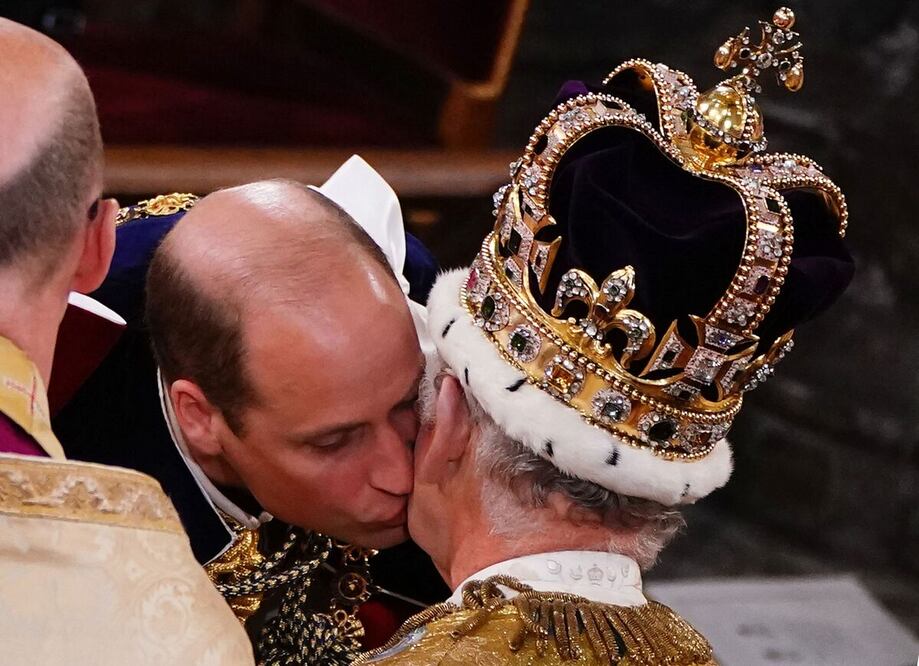 El príncipe William besa a su padre, el rey Carlos III, con la corona de San Eduardo, durante la Ceremonia de Coronación del Rey dentro de la Abadía de Westminster en el centro de Londres. Foto: AFP