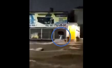 VIDEO: Mujer intenta cruzar una calle inundada y es arrastrada por la corriente en Culiacán