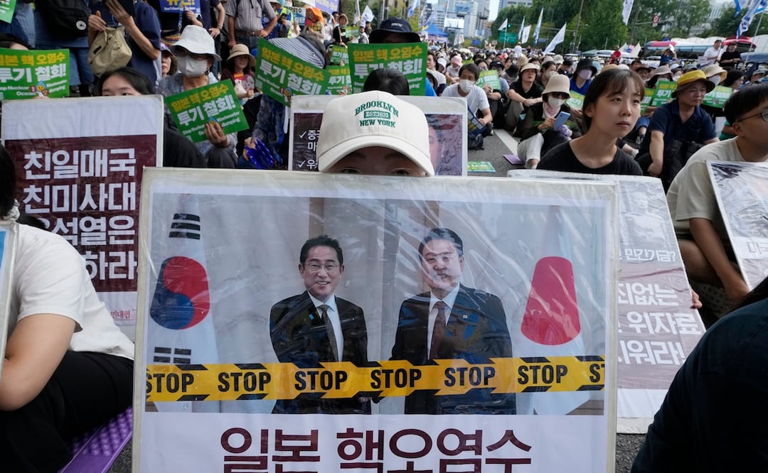 Un manifestante sostiene una pancarta que muestra una imagen del primer ministro japonés, Fumio Kishida, y del presidente surcoreano, Yoon Suk Yeol, a la derecha, durante una manifestación para exigir que Japón deje de liberar al mar agua radiactiva. Foto: AP