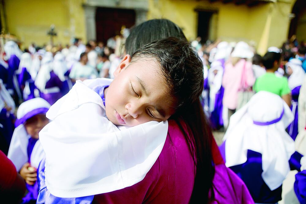 Un niño descansa en el hombro de su madre, durante una procesión en Semana Santa, en Antigua, Guatemala. Expertos alertan de que en este país, como en otros de Centroamérica, no se respetan los derechos maternos (ARCHIVO / AP)