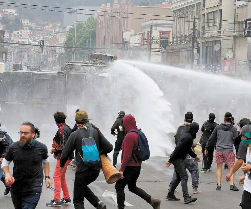 Violencia. Manifestantes chilenos se enfrentaron ayer contra las fuerzas de seguridad, en Valparaíso. RODRIGO GARRIDO. REUTERS