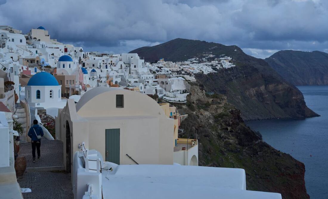 Un turista se acerca a las iglesias ortodoxas con cúpulas azules en la ciudad de Oia, en la isla de Santorini, Grecia, afectada por un terremoto, el martes 4 de febrero de 2025. Foto: AP