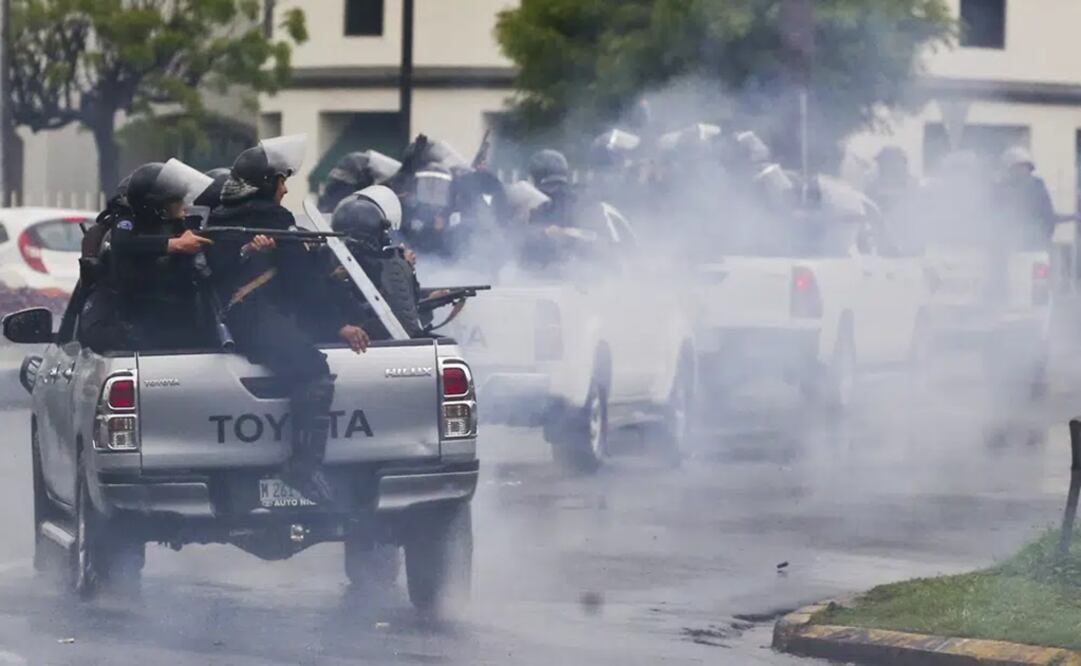 Policías antidisturbios a bordo de camionetas abren fuego con escopetas. Foto: AP 