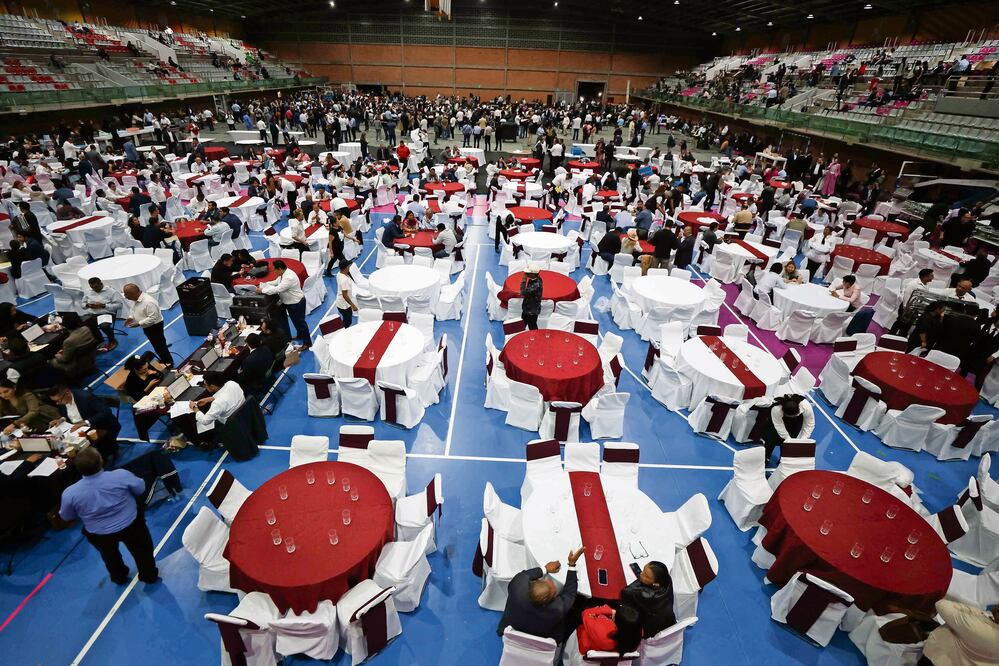A las 20:00 horas un miniejército de meseros instaló mesas para servir la cena en la cancha de basquetbol contigua a la sede alterna, aunque los asesores no dejaban de repartir frituras. Foto: de DIEGO SIMÓN SÁNCHEZ. EL UNIVERSAL