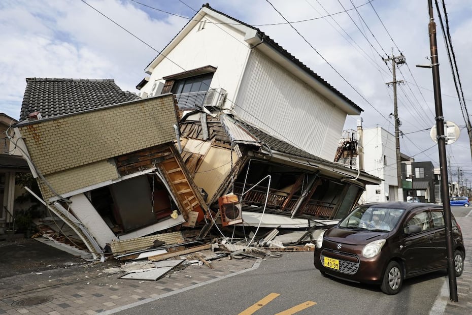 Un vehículo pasa junto a viviendas colapsadas por el terremoto en Yatsushiro, en la prefectura japonesa de Kumamoto. FOTO: AP