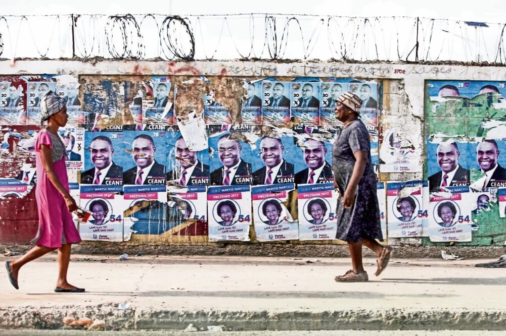 Dos mujeres pasan por un muro con propaganda de las próximas elecciones presidenciales en Haití, que se realizarán el 20 de noviembre (Fotos: JORGE SERRATOS. EL UNIVERSAL)