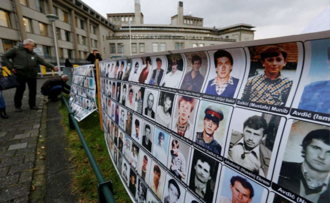 People attach banners to the fence before the trial of former Bosnian Serb military commander Ratko Mladic – Photo: Michael Kooren/REUTERS