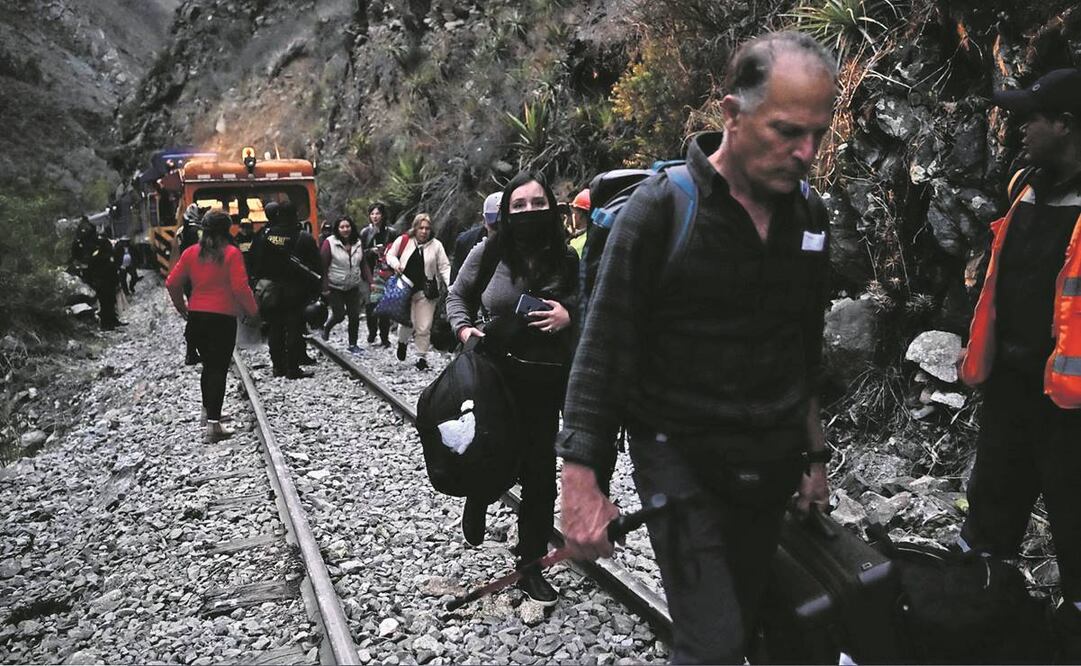 Los turistas varados que visitaban Machu Picchu caminaron a lo largo de las vías, después de ser evacuados en tren a Ollanta y tambo. Foto: Martin Bernetti/AFP