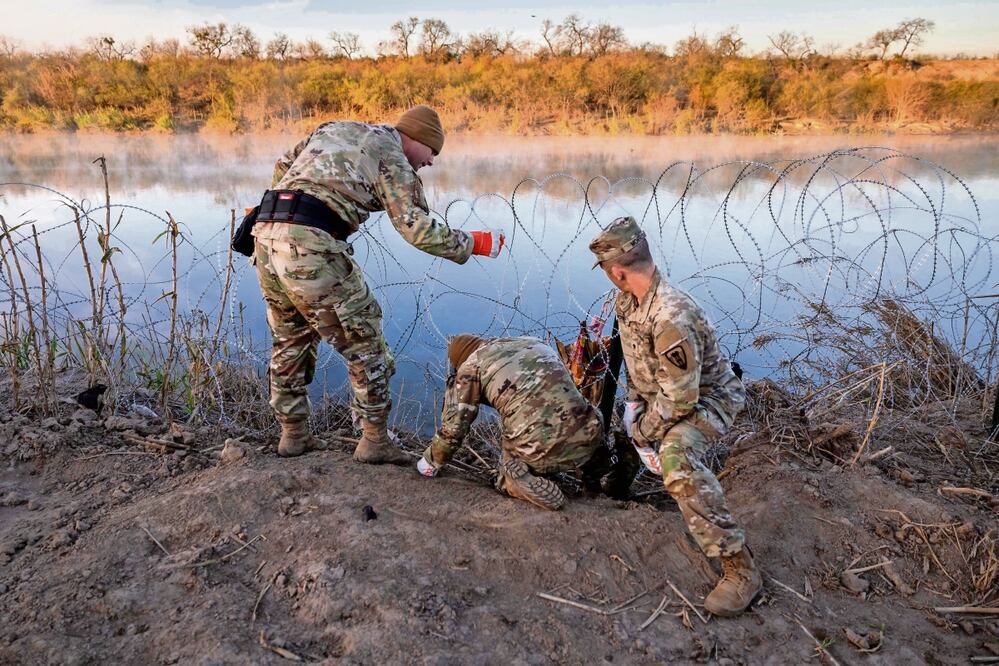 Soldados de la Guardia Nacional de Texas instalan alambre de púas adicional a lo largo del río Grande (Bravo), en Eagle Pass, Texas. Foto: John Moore / AFP