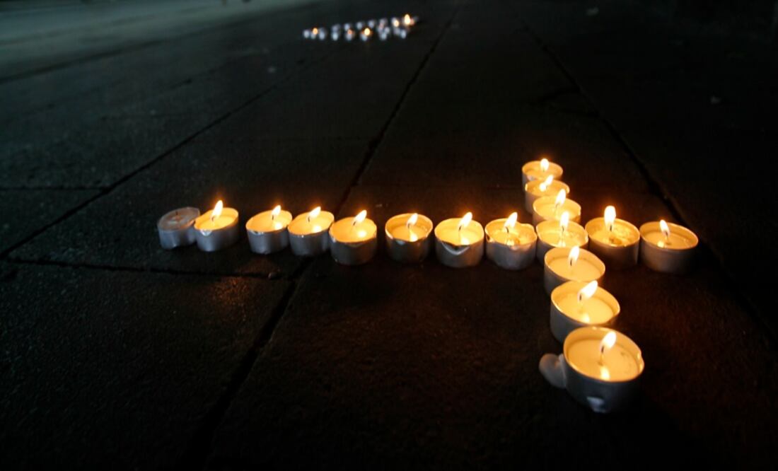 Candles in the form of a cross – Photo: Wolfgang Rattay/REUTERS