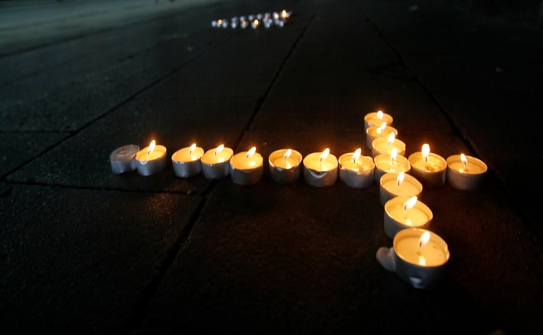 Candles in the form of a cross – Photo: Wolfgang Rattay/REUTERS