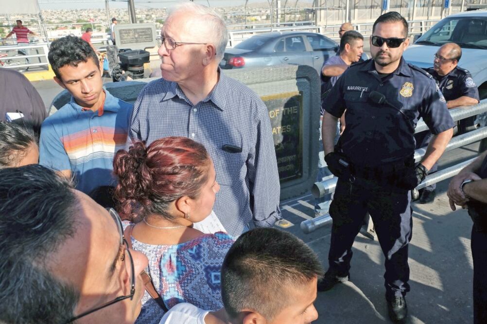 Un oficial de aduanas de EU observa a las familias migrantes (XINHUA)