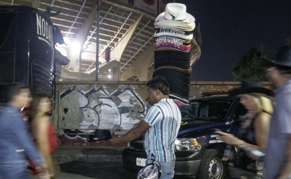 Comienzan a llegar algunos fans a la plaza de toros donde realizan compras de sombreros símbolo del género musical. Foto: Yaretzy M. Osnaya/EL UNIVERSAL.