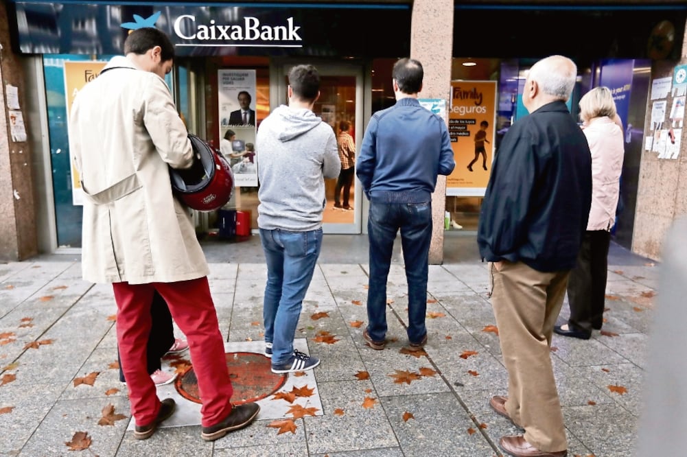 Miles de catalanes retiraron dinero ayer de los principales bancos españoles como parte de un boicot contra el gobierno de Mariano Rajoy (GONZALO FUENTES. REUTERS)