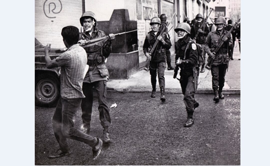 Se observa como soldados intentan disuadir a un joven de retirarse al golpearlo con la culata de su arma. Foto: Cortesía UNAM
