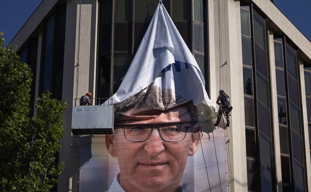 Trabajadores retiran un cartel electoral que muestra a Alberto Núñez Feijóo, líder del conservador Partido Popular (PP). Foto: AP