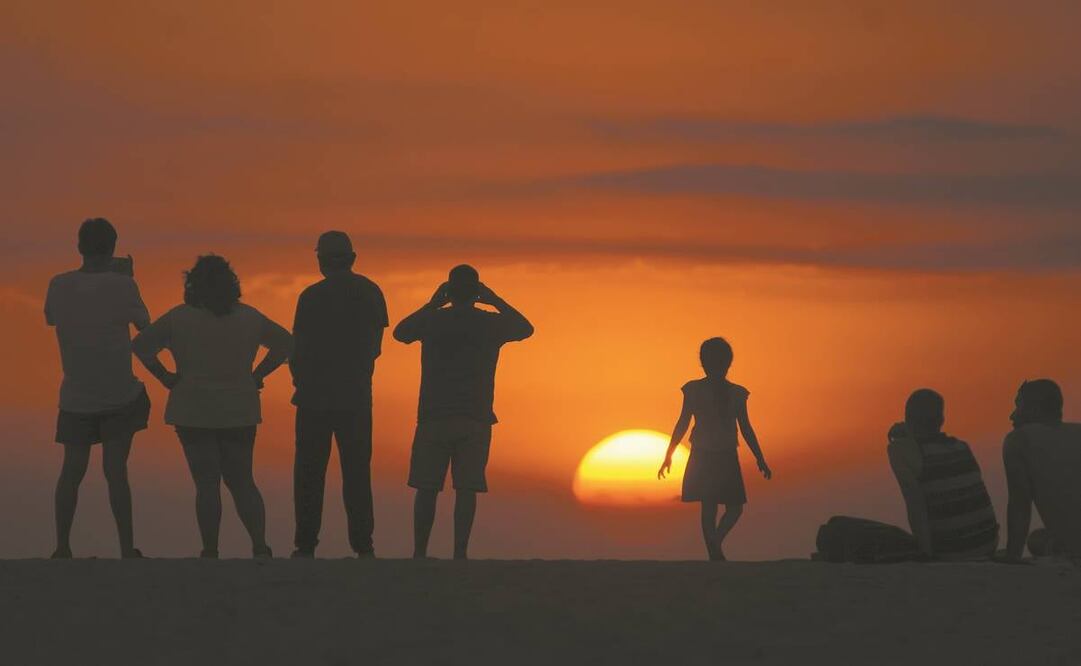 Cientos de turistas y familias completas se reunieron en la playa de Zicatela a ver el atardecer, muchos sin cubrebocas o aplicando la sana distancia. Foto: Edwin Hernández/ El Universal.