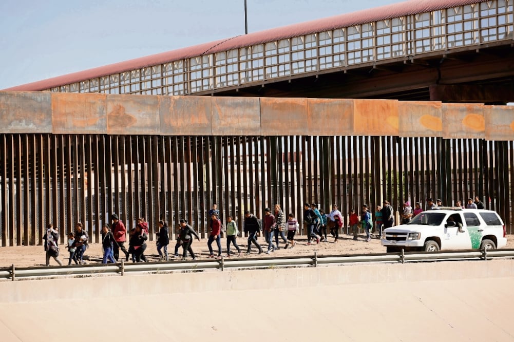 Migrantes son escoltados por elementos de la Patrulla Fronteriza, tras cruzar ilegalmente a Estados Unidos para pedir asilo, en El Paso, Texas. Las autoridades de EU se quejan de que el sistema migratorio ha llegado a “un punto de quiebre”. / REUTERS