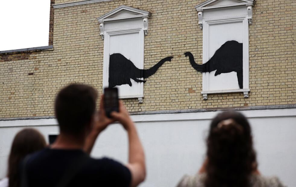 Un grupo de personas observan la nueva obra del artista anónimo británico Banksy en Chelsea, London.
Foto: EFE / Randy Rain