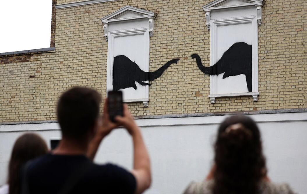 Un grupo de personas observan la nueva obra del artista anónimo británico Banksy en Chelsea, London.
Foto: EFE / Randy Rain