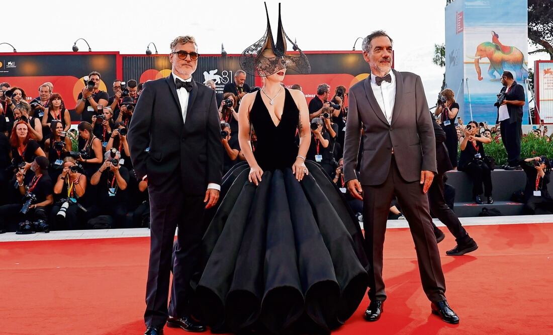Joaquin Phoenix, Gaga y el director Todd Phillips a su paso por la alfombra roja, en la que saludaron a sus fans. Fotos: EFE y AP