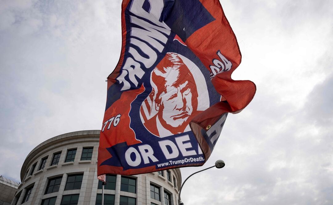 Un partidario del expresidente estadounidense Donald Trump enarbola una bandera pro-Trump fuera del Palacio de Justicia de los Estados Unidos E. Barrett Prettyman. Foto: AFP