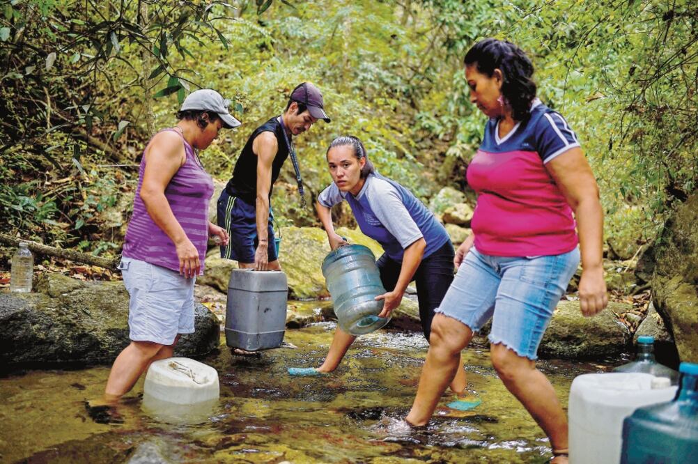 Precariedad. Tras el apagón, los venezolanos se quedaron sin agua, por lo que optaron por rellenar garrafones del parque Waraira Repano, en Caracas. Foto: FEDERICO PARRA. AFP
