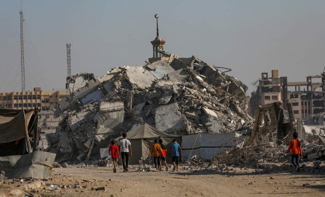 Niños palestinos caminan junto a los escombros de edificios destruidos en la Ciudad de Gaza, Franja de Gaza, el 28 de octubre de 2025, en medio de un alto el fuego entre Israel y Hamás. Tras las acusaciones israelíes de que Hamás violó el alto el fuego, el primer ministro Netanyahu ordenó ataques militares contra la Franja de Gaza el 28 de octubre. En respuesta, Hamás anunció el aplazamiento de la entrega prevista del cuerpo recuperado de un rehén, alegando violaciones de la tregua por parte de Israel. Foto: EFE
