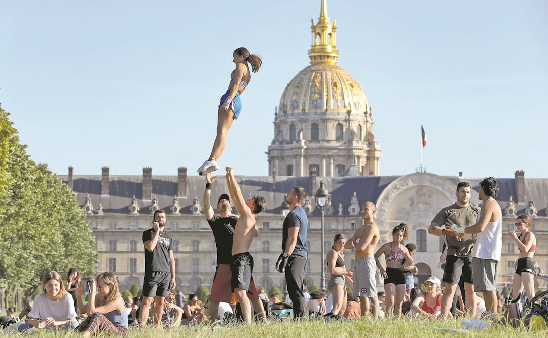 Franceses realizan acroba cias en el jardín de la Explanada de los Inválidos, en París, tras levantar restricciones. Foto: LUDOVIC MARIN. AFP