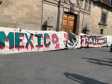 Grupo de mujeres coloca manta por el 8M en Palacio Nacional