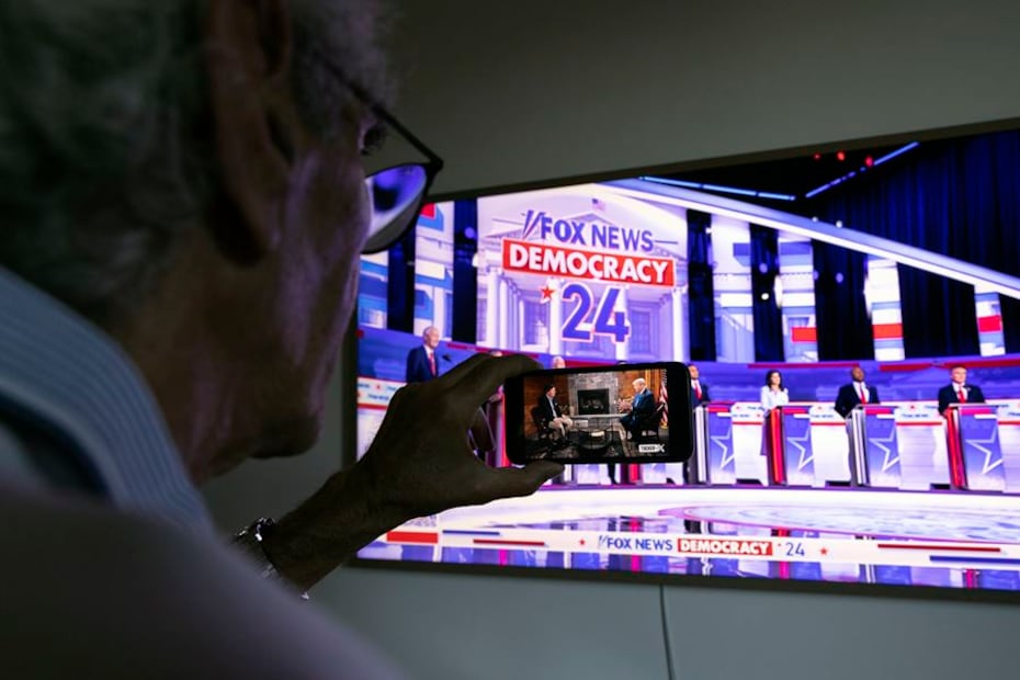 Televidente sigue el debate republicano y la entrevista a Trump al mismo tiempo. Foto: EFE