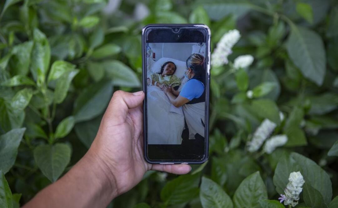 Mynor Cardona muestra una foto en su teléfono celular de su hija, Yenifer Yulisa Cardona Tomás, en el hospital mientras recibe una visita, en la Ciudad de Guatemala. Foto: AP 