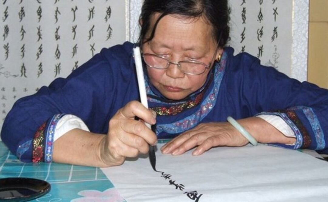 Una mujer dibuja los caracteres de este lenguaje escrito chino exclusivo para las mujeres. Foto: CONDADO DE JIANGYONG vía BBC