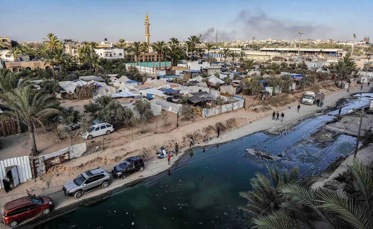 Esta vista aérea muestra tiendas de campaña utilizadas como refugios temporales para palestinos desplazados a lo largo de una calle cubierta de aguas residuales estancadas