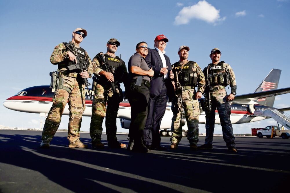El candidato presidencial republicano Donald Trump posa con agentes de seguridad, después de un evento de campaña, ayer, en Orlando, Florida (CARLO ALLEGRI. REUTERS)