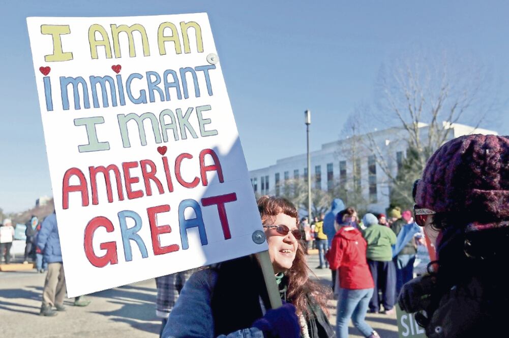 Ellen Furstner, de 62 años, en la protesta de ayer en Salem, Oregon, contra las políticas de Trump. El cartel dice: “Soy migrante y hago grande a EU” (AP)