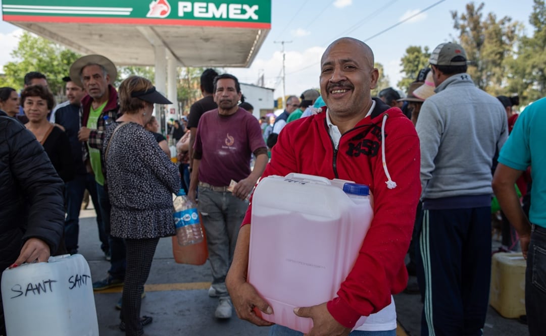 Tras días de espera, desvelos, hambre y desesperación, lo logró. Moisés Cortés abraza feliz su bidón con gasolina. “Hasta nos sentimos alegres. Vamos a dormir en casa”, dice el michoacano con una sonrisa. Foto: RODOLFO AYALA. EL UNIVERSAL