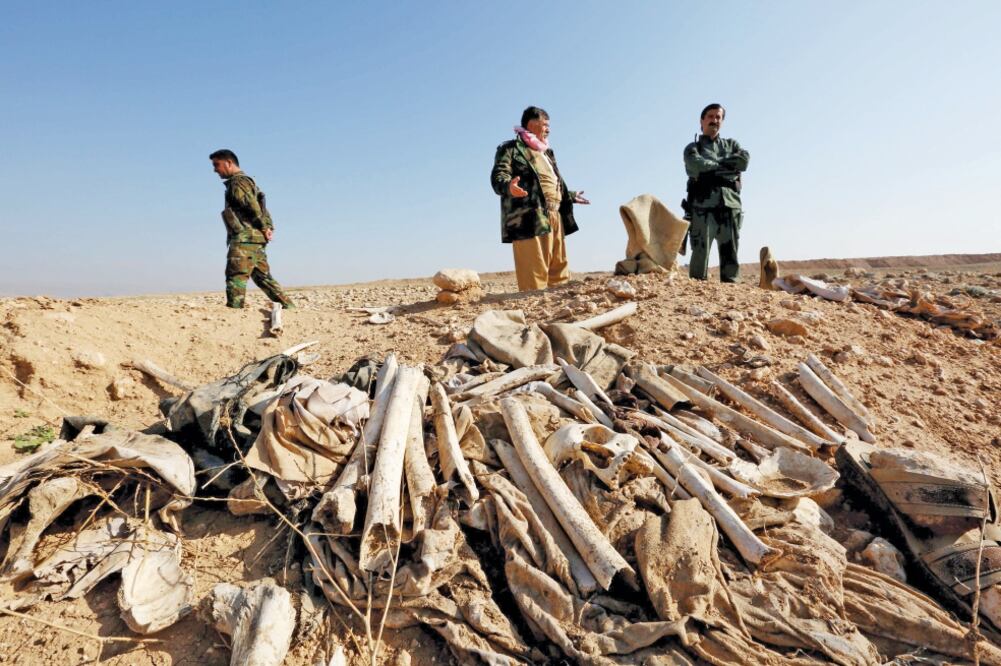 Kurdos vigilan la zona donde se encontraron fosas masivas, a las afueras de Sinkar, en Irak. Se cree que los huesos pertenecen a miembros de la comunidad yazidí (ARI JALAL. REUTERS)