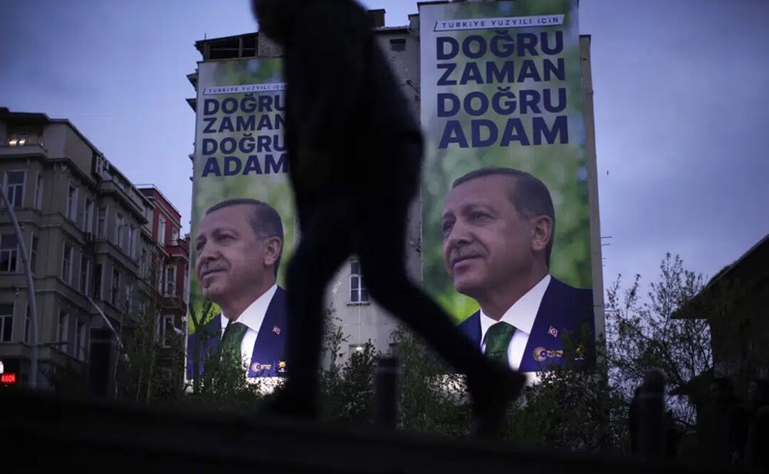 Un hombre pasa por delante de un cartel electoral con la imagen del presidente de Turquía, Recep Tayyip Erdogan, en Estambul, Turquía. Foto: AP