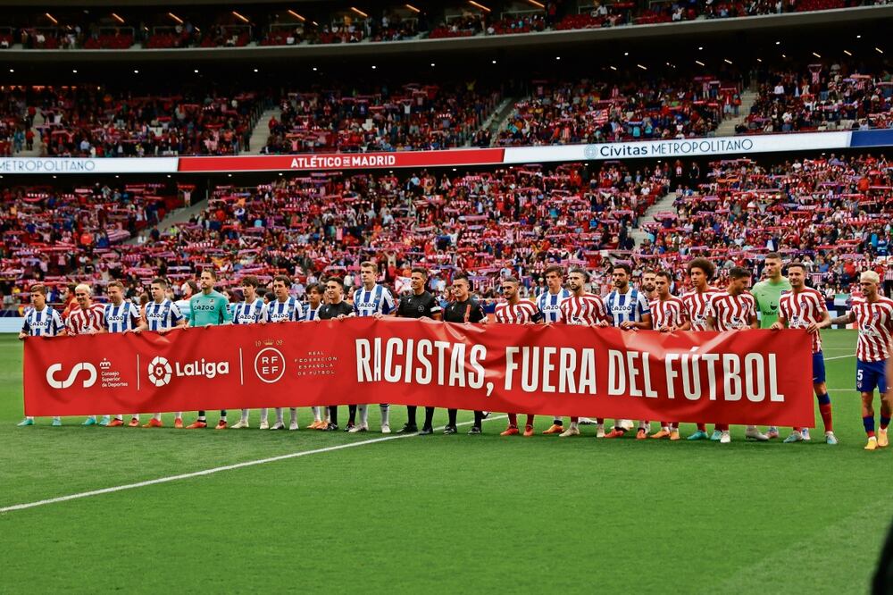Los jugadores del Atlético de Madrid y de la Real Sociedad portan una pancarta contra el racismo, luego de los insultos que recibió el jugador brasileño Vinicius Junior, del Real Madrid.