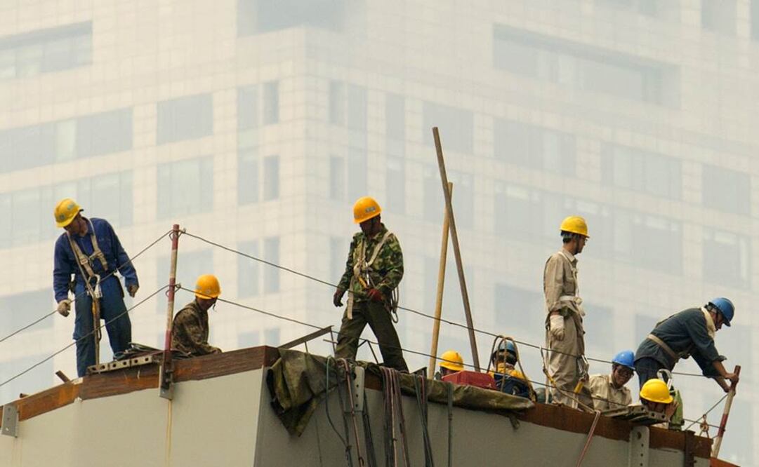 Obreros trabajan en un día con aire contaminado en Beijing. Foto: AP