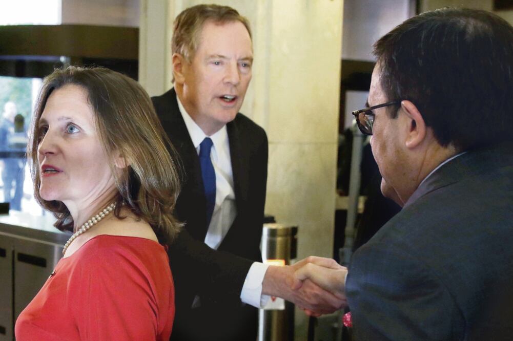 Robert Lighthizer, representante comercial de Estados Unidos, estrecha las manos con Ildefonso Guajardo, secretario de Economía, detrás de Chrystia Freeland, ministra canadiense de Relaciones Exteriores, en Virginia. (YURI GRIPAS.REUTERS)