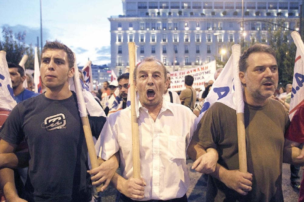Miles de griegos salieron a las calles ayer para rechazar el rescate. En la foto, gente cercana al sindicato comunista PAME protesta frente al Parlamento (ALEXANDROS VLACHOS. EFE)