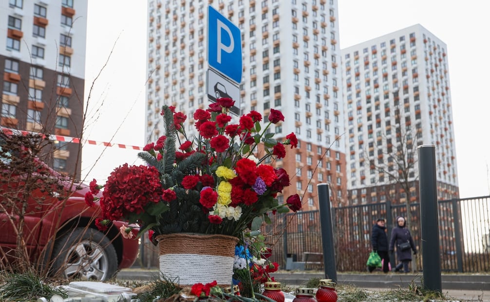 La gente pasa junto a flores colocadas en memoria del teniente general ruso Fanil Sarvarov en el lugar del atentado con coche bomba en Moscú, Rusia, el 24 de diciembre de 2025. El 22 de diciembre, un coche que transportaba al teniente general Fanil Sarvarov, jefe de la Dirección de Entrenamiento Operativo de las Fuerzas Armadas de Rusia, explotó en el sur de Moscú, informó el Comité de Investigación de Rusia. Foto: EFE
