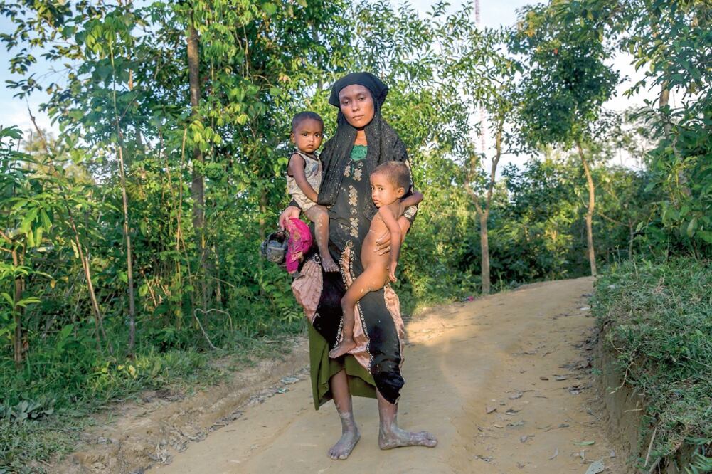 Víctimas. Una madre con sus hijos camina hacia un albergue en Bangladesh, donde hay una crisis de refugiados. (DAR YASIN. AP)