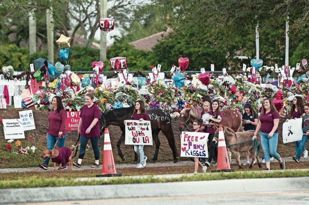 Policías, familiares y amigos, algunos con animales para terapia, acompañaron a los alumnos de la escuela Marjory Stoneman Douglas, en Parkland, Florida, a su regreso a clases tras el tiroteo del 14 de febrero. (MATIAS J. OCNER. AP)