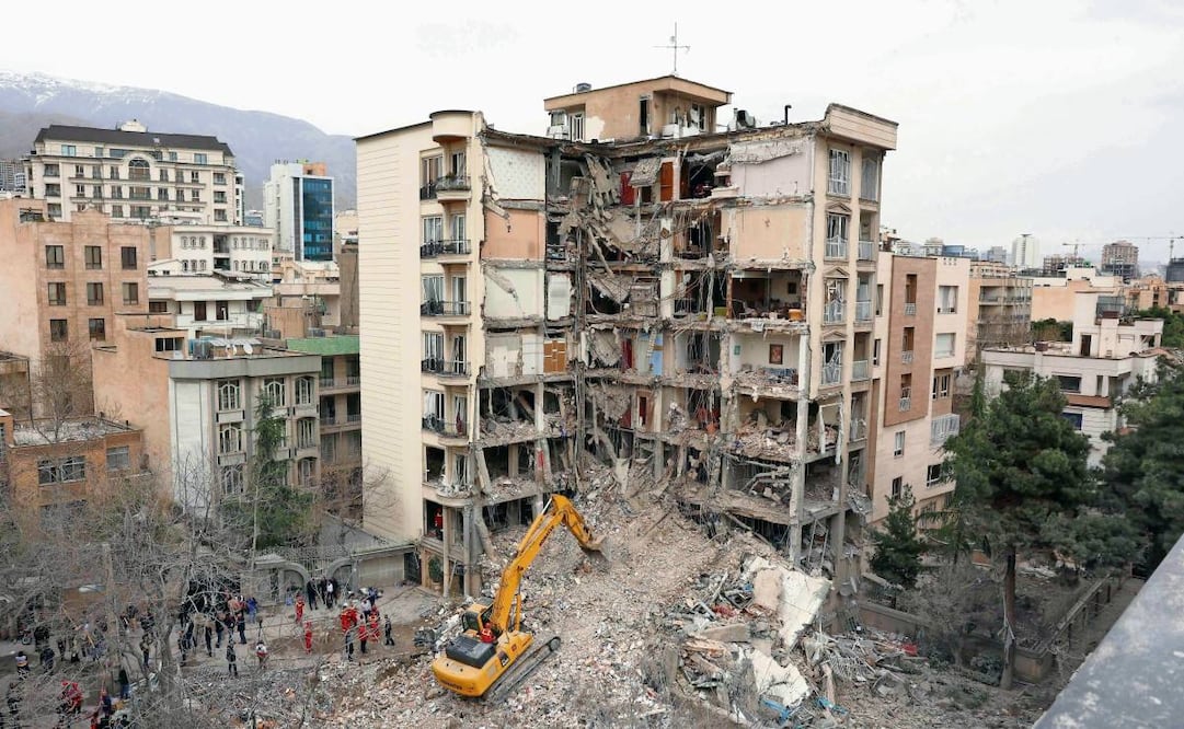 Una excavadora retira escombros de edificios residenciales destruidos en el norte de la capital iraní, el 23 de marzo de 2026. Foto: AFP