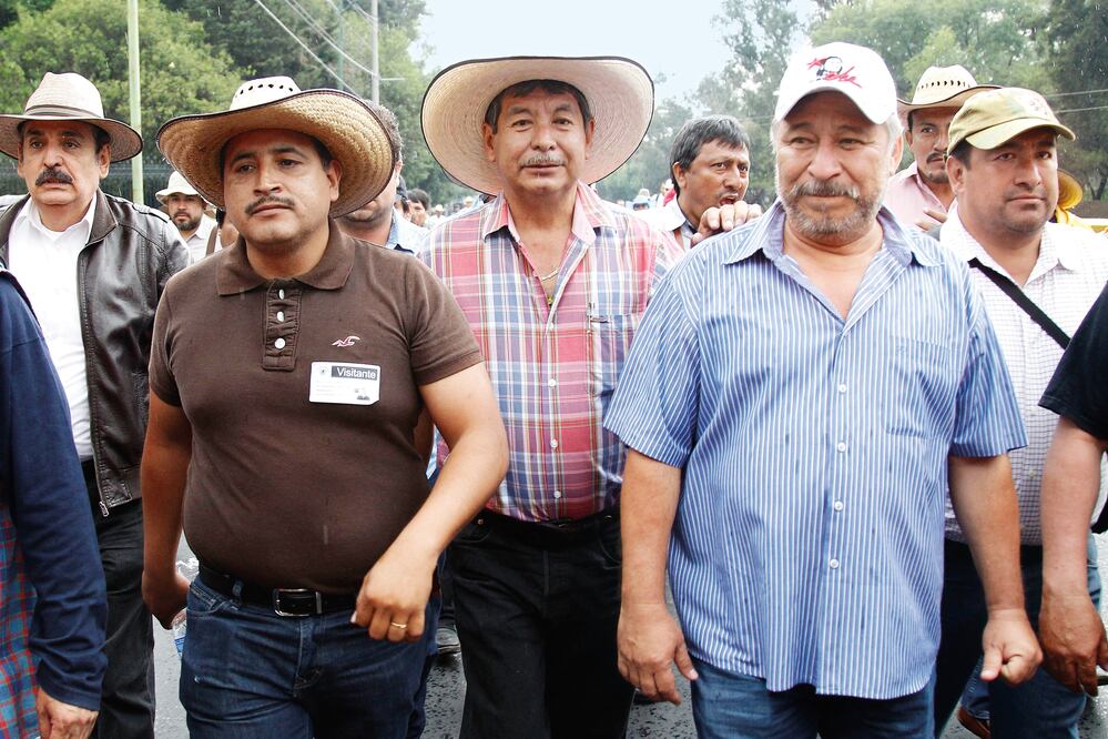 El líder de la Sección 22 de la CNTE, Rubén Núñez (centro), encabezó ayer una marcha “bl i n d ado” por otros dirigentes de la disidencia magisterial (ARIEL OJEDA. EL UNIVERSAL)